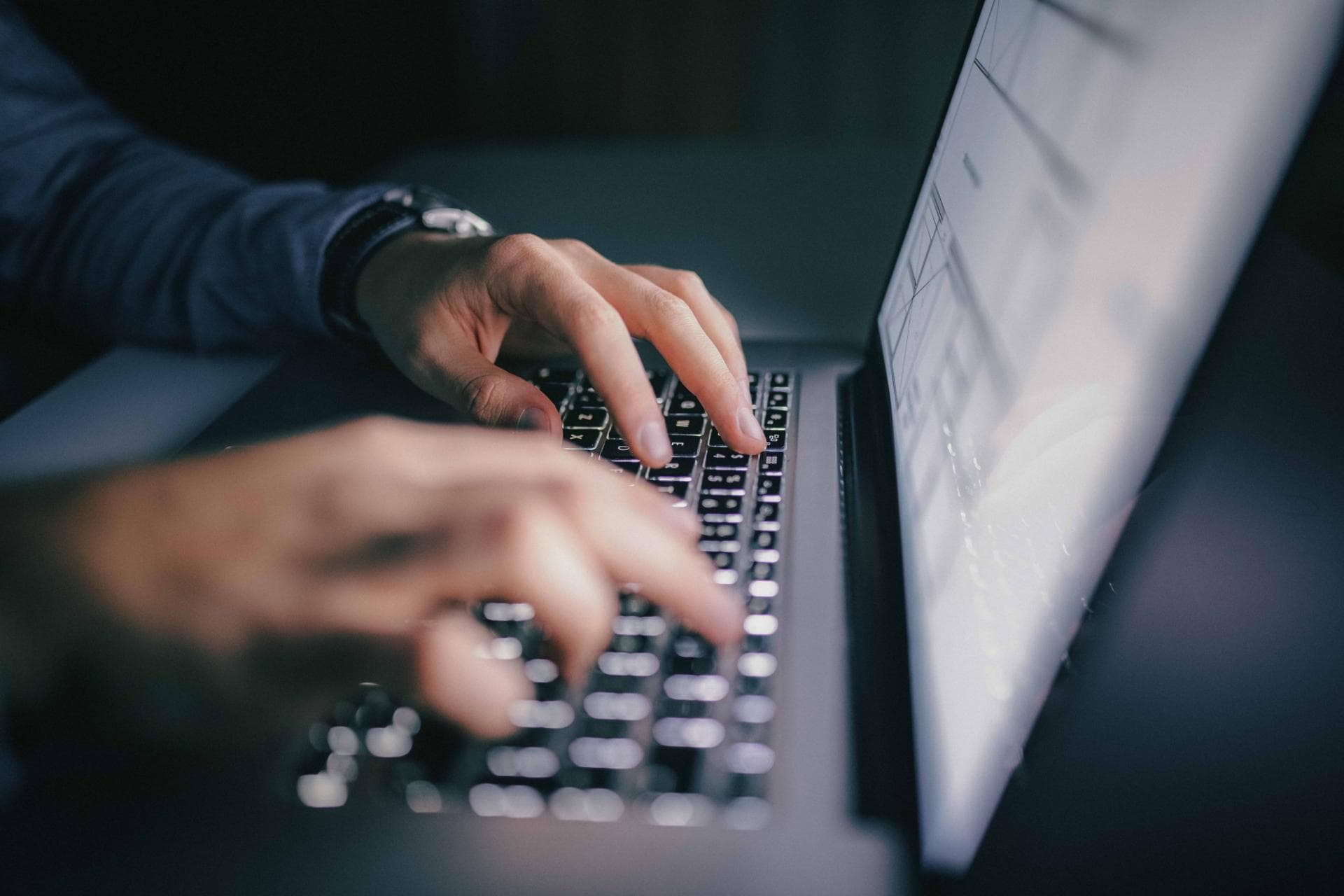 Close up of hands typing on laptop. night work concept.